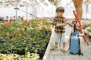 Young Kid Using Organic Insect Control and IPM from Rocky Mountain BioAG Inside a Greenhouse